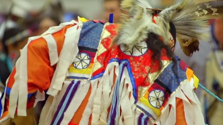 Dancer in ornate clothing and beads dances at a traditional American Indian Powwow